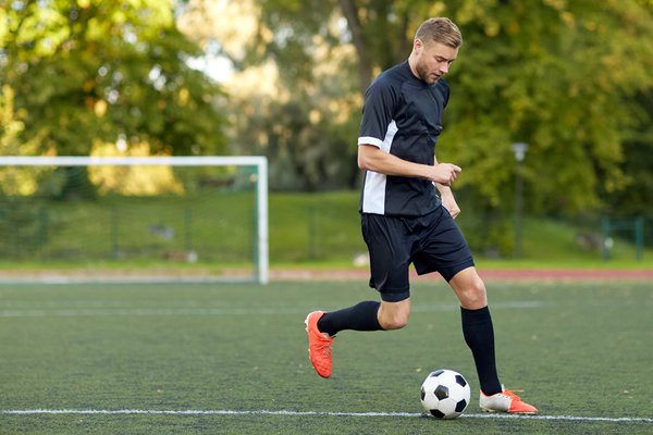 Footballer playing on artificial pitch