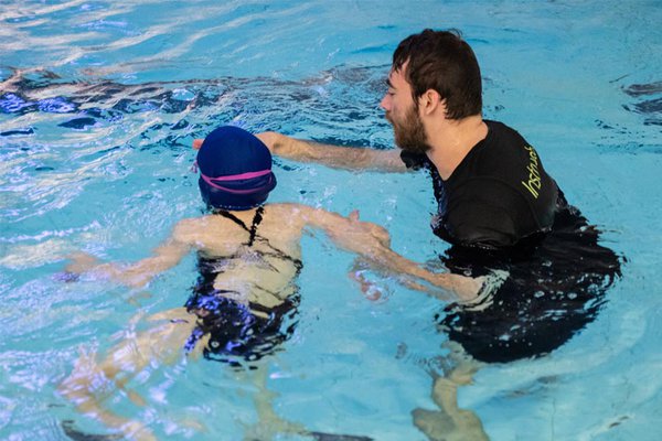 Swim Teacher instructing pupil in the pool