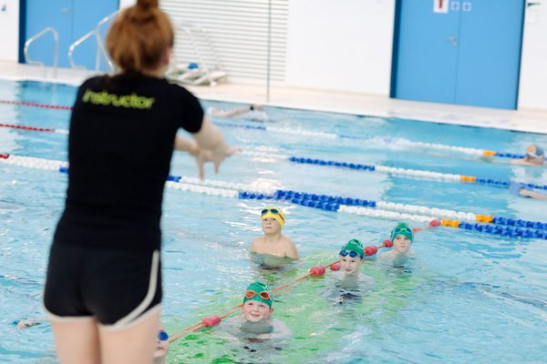 Swim teacher instructing kids swim lesson