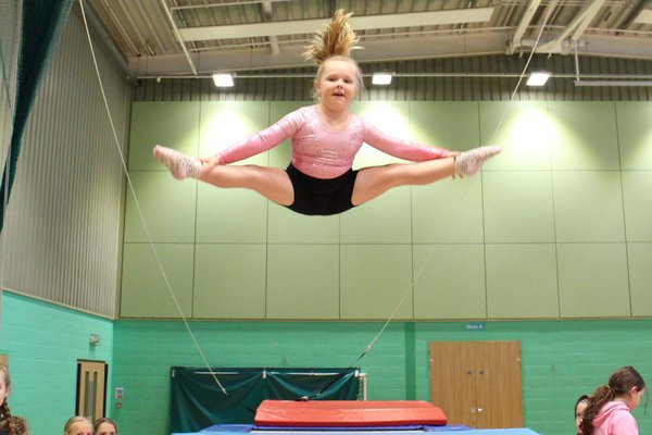 Girl performing a straddle on a trampoline