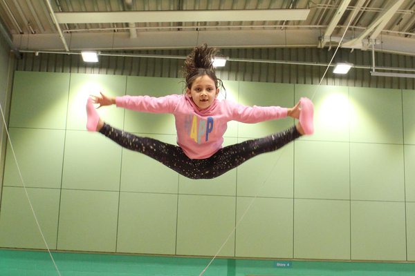 Girl performing a straddle on a trampoline